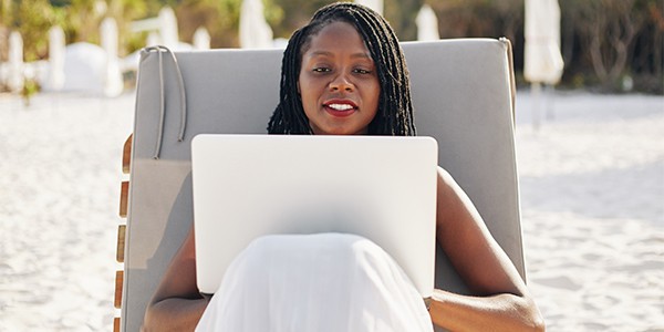 Woman in beach chair with laptop.